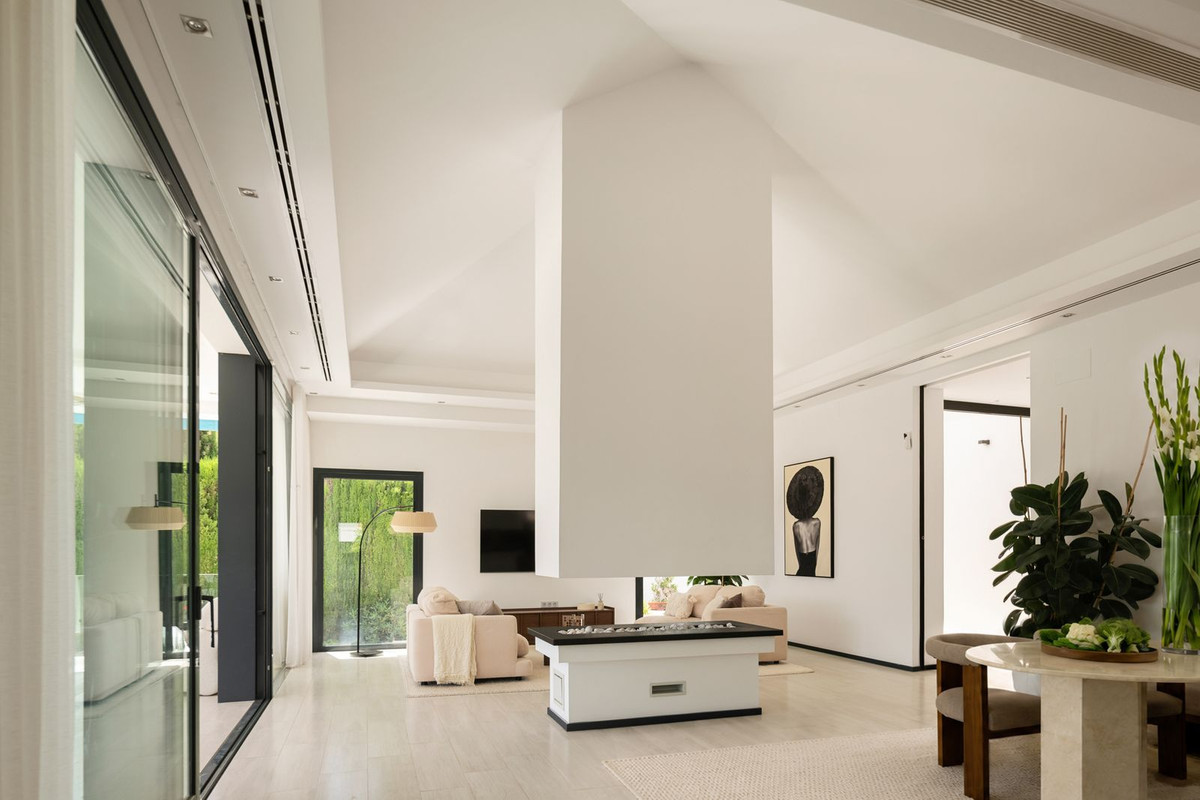 Open living space with high pyramid ceiling, central fireplace and travertine dining area