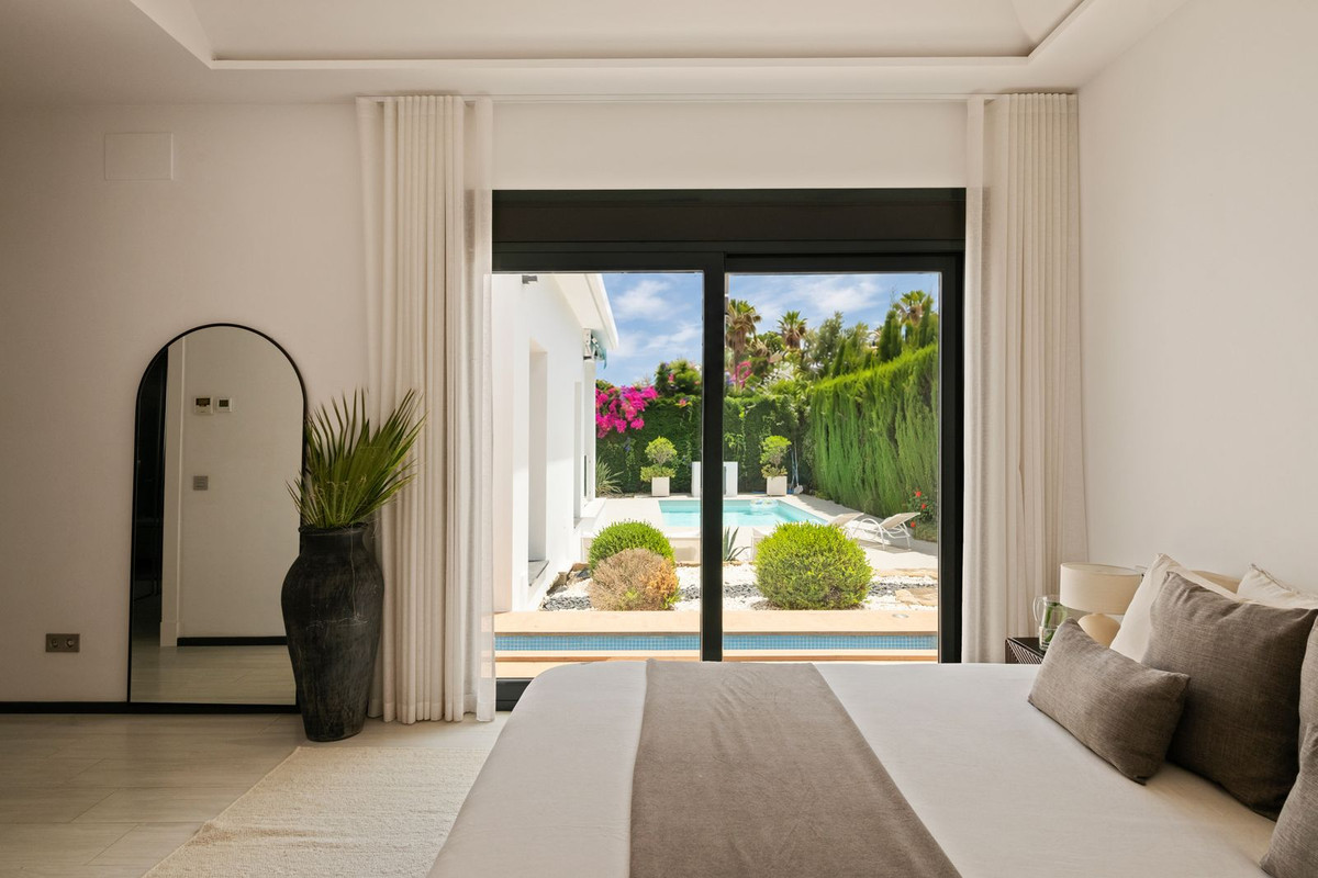 Principal bedroom with sliding door directly to the pool and bougainvillea outside
