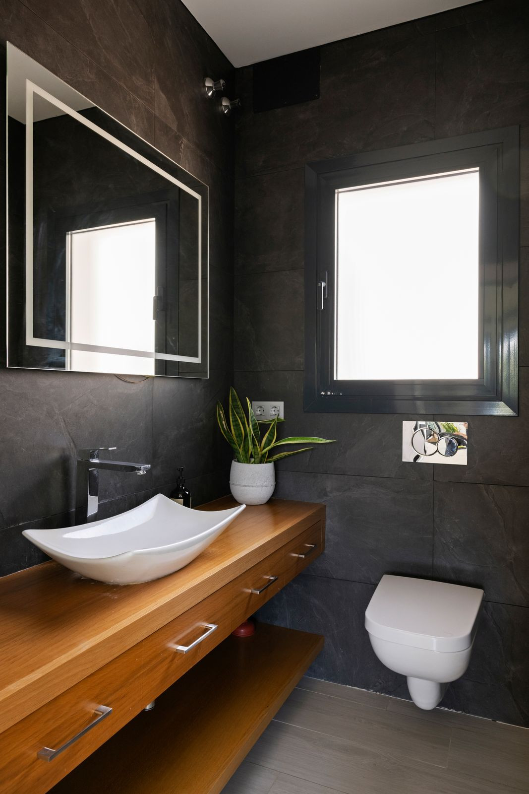 Guest cloakroom with dark slate, white basin and solid timber counter