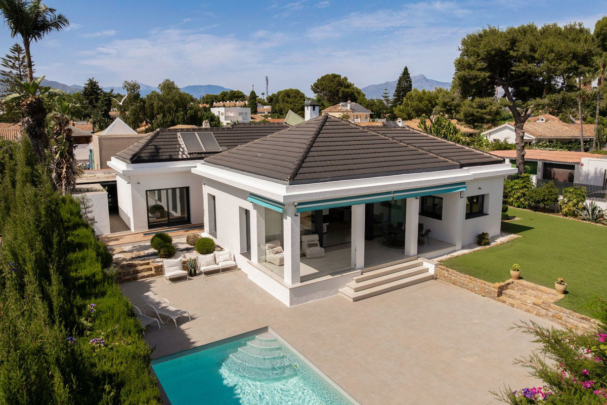 Aerial view of the villa with pool, terrace and mountains behind