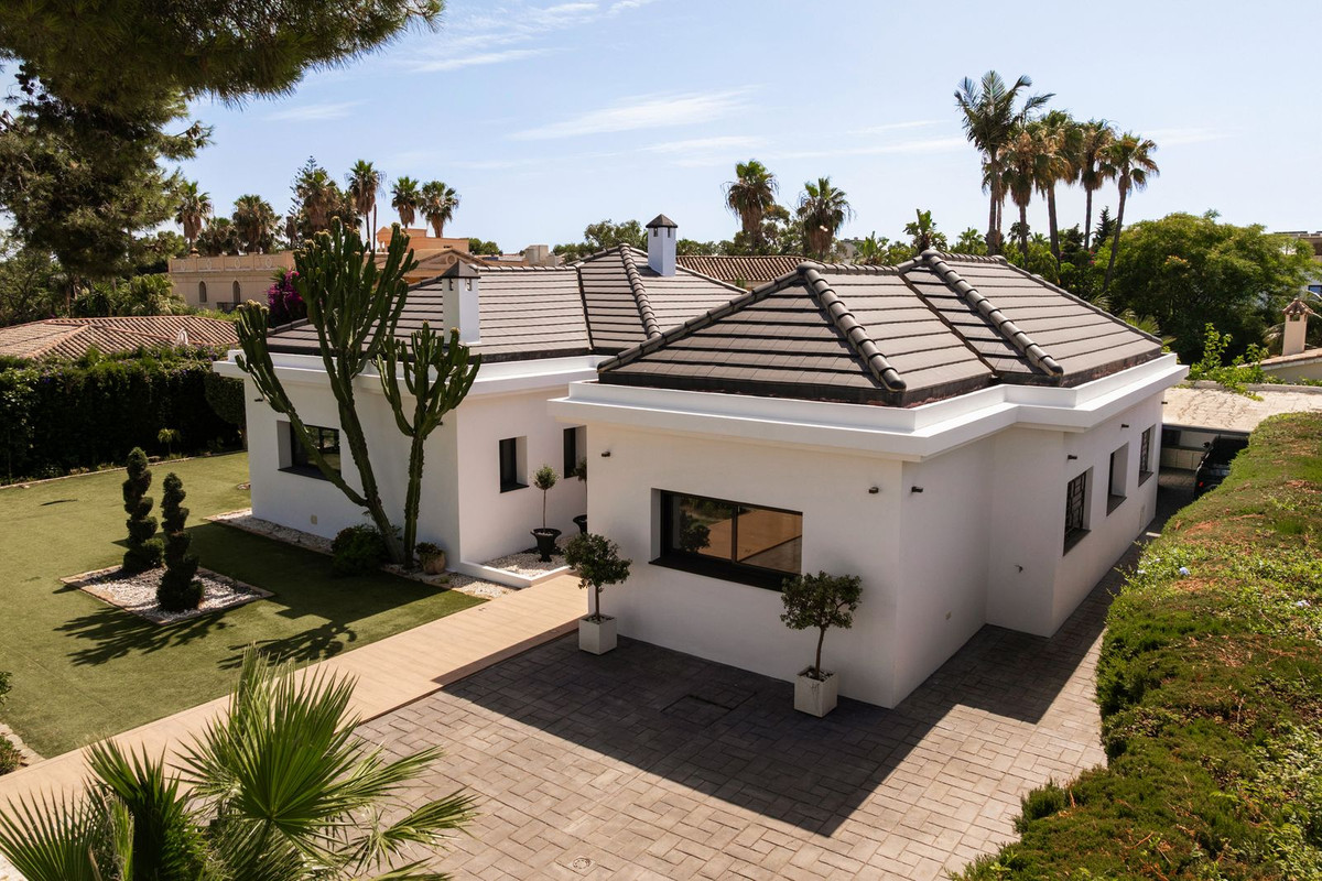 Aerial view of the entrance side with driveway, path and potted olive trees